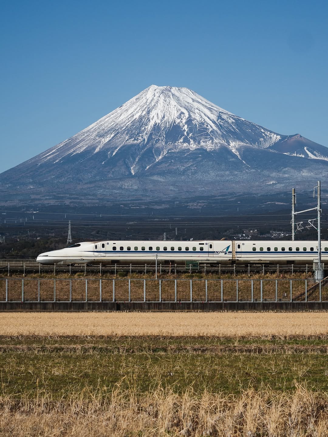 Standing in the middle of nowhere, yet feeling like I’m exactly where I’m meant to be. The silence of these open fields, the crisp air, and then suddenly—life rushes past me at 300 km/h. The Shinkans